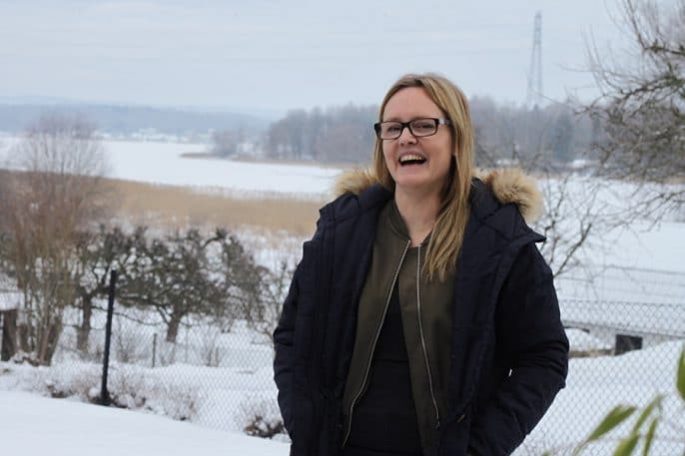 Susanne står ute i snön och skrattar