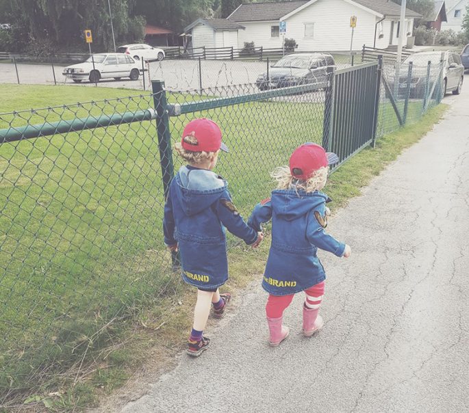 Sebastian och Max går hand i hand utomhus i matchande jackor och kepsar