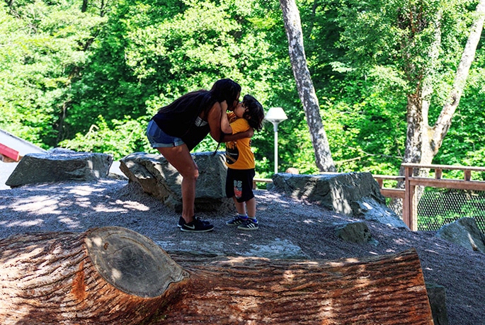 Linn och Tristan står på en sten och pussar varandra på munnen
